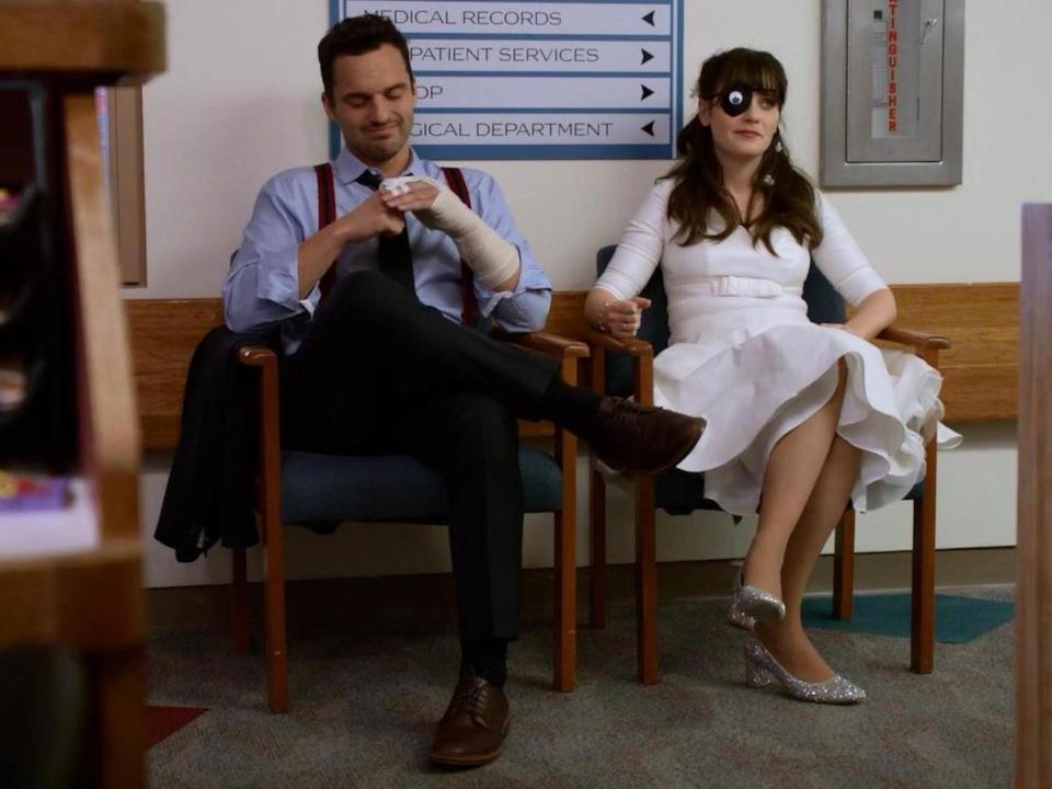 Nick and Jess sit in chairs at a hospital on "New Girl."