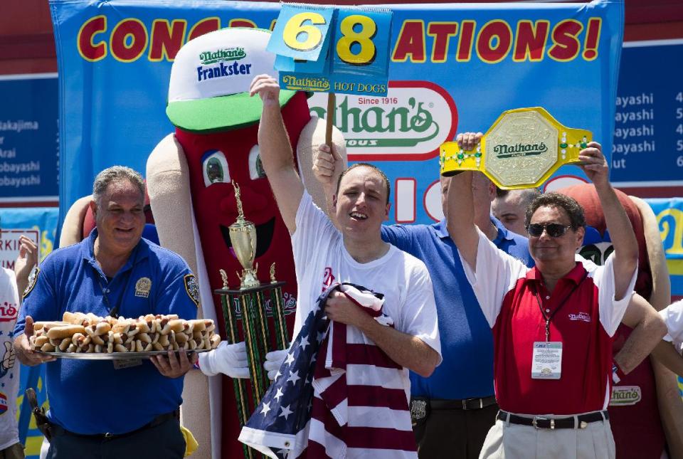 Five-time reigning champion Joey Chestnut celebrates after he wins his sixth straight Coney Island hot dog eating contest on Wednesday, July 4, 2012 at Coney Island, in the Brooklyn borough of New York. Chestnut tied his personal best and the record with eating 68 hot dogs. Last year, Chestnut won with 62 hot dogs. (AP Photo/John Minchillo)