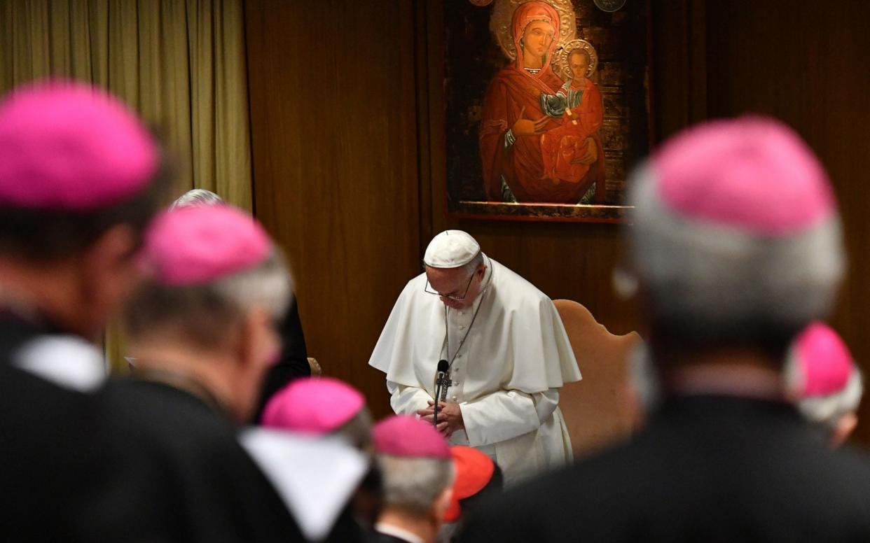 Pope Francis prays during the opening of the global child protection summit at the Vatican - AFP