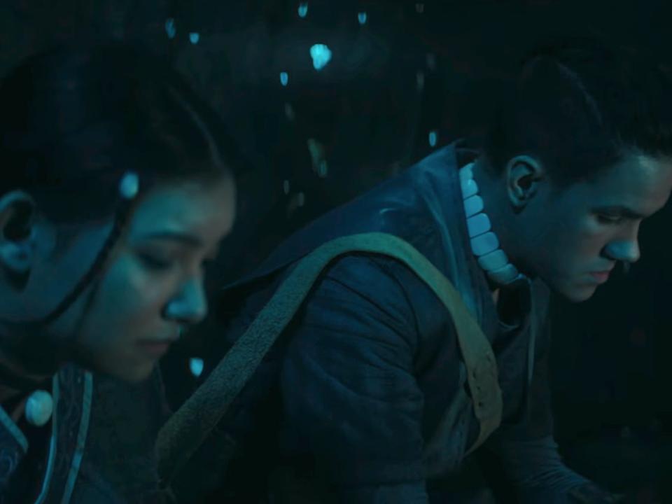 katara and sokka in the live action avatar, sitting together in a cave with glowing crystals