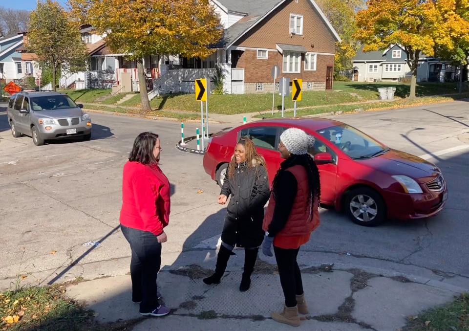 Tired of speeding drivers along Locust Street, Amani neighborhood residents worked with AARP Wisconsin, Amani United, The Dominican Center and the Wisconsin Bike Federation to have the city install a traffic circle on Monday, Oct. 30 at the corner of 25th and Locust. Amber Miller (left), AARP Wisconsin's associate state director of community outreach, talks with Amani resident Barbara Smith (right) and Maricha Harris, (center) executive director of the Dominican Center, about how the new traffic circle will make the neighborhood safe for pedestrians and drivers.