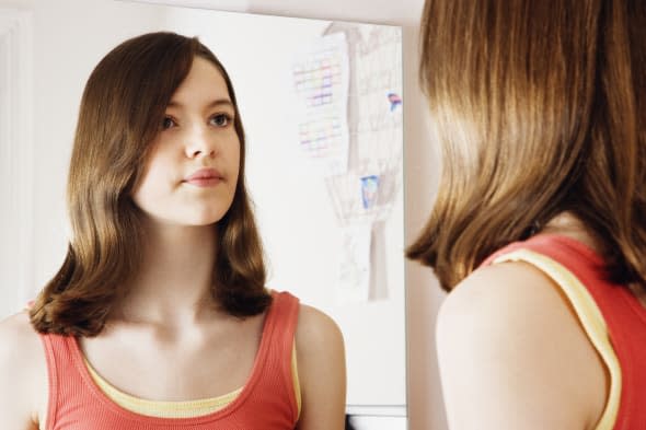 Girl looking at reflection in mirror