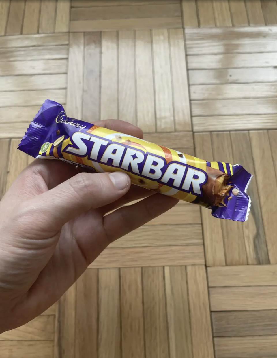 Hand holding a Cadbury Starbar chocolate bar