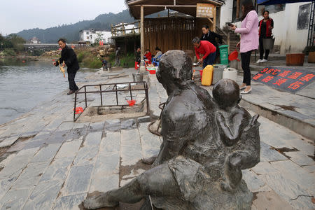 Villagers fill containers with water from a hot spring attraction in Rucheng county, Hunan province, China December 2, 2018. Picture taken December 2, 2018. To match Insight CHINA-ECONOMY/DEBT-RUCHENG. REUTERS/Shu Zhang