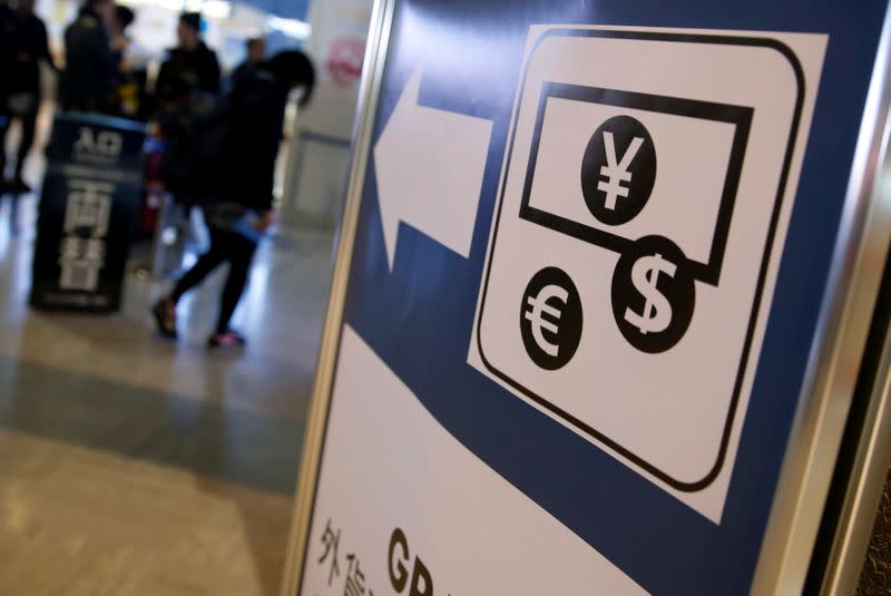 Currency signs of Japanese Yen, Euro and the U.S. dollar are seen on a board outside a currency exchange office at Narita International airport