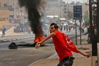 <p>A Palestinian throws stones towards Israeli security forces during clashes after a protest marking the 70th anniversary of Nakba — also known as Day of the Catastrophe in 1948 — and against the US’ relocation of its embassy from Tel Aviv to Jerusalem, at the main entrance of the occupied West Bank city of Bethlehem on May 15, 2018. (Photo: Musa Al Shaer/AFP/Getty Images) </p>