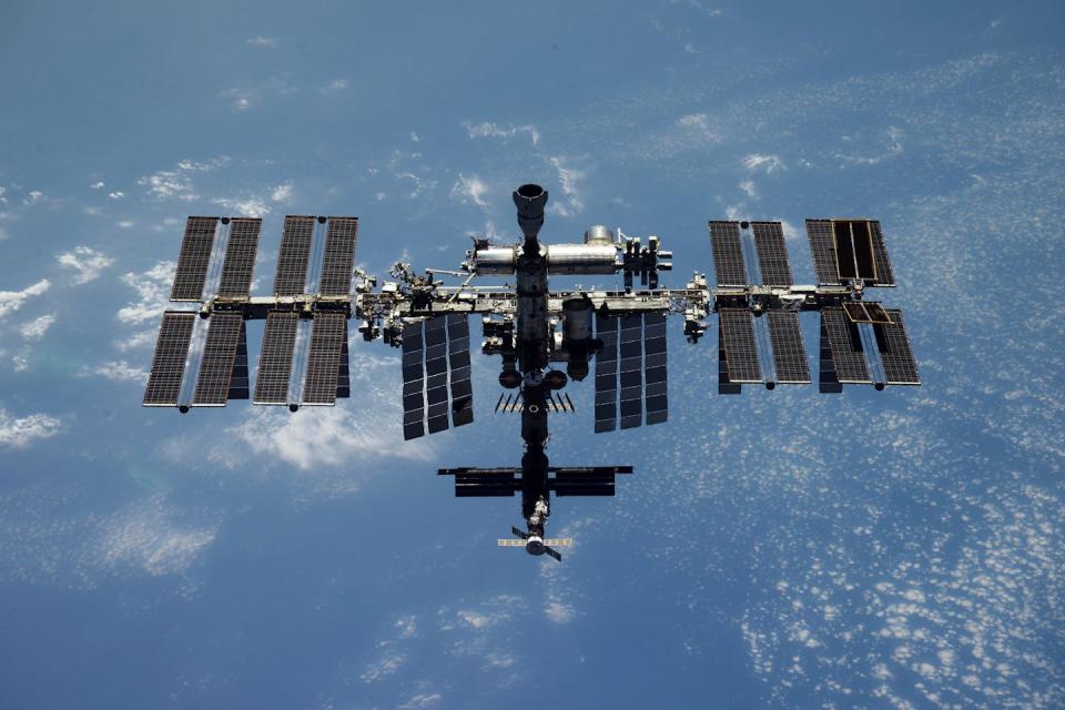 The ISS, a cylindrical spaceship with solar panels on each side.