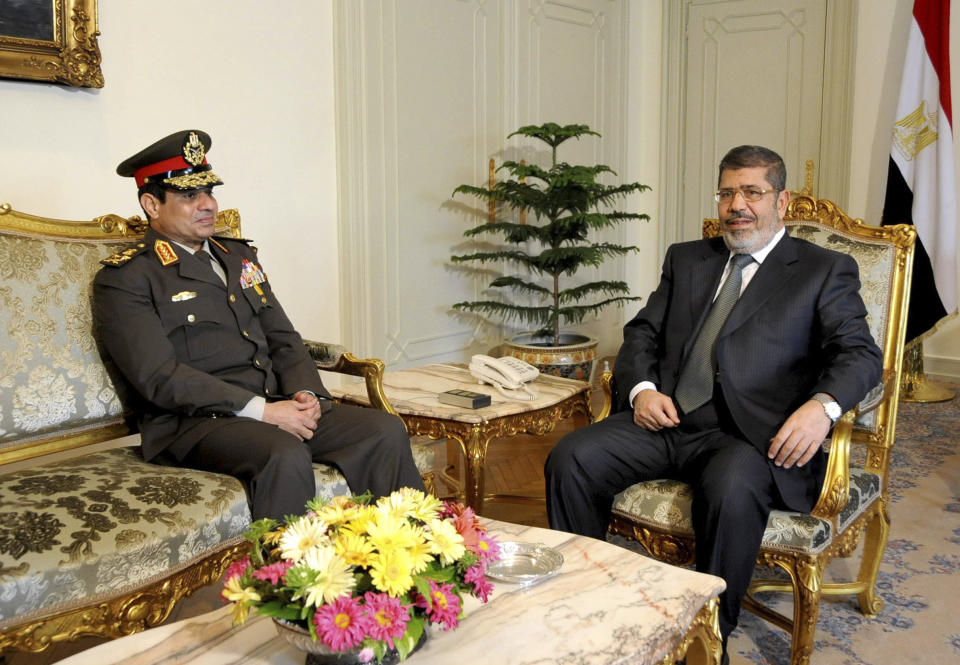 FILE - In this Thursday Feb, 21, 2013 file photo, released by the Egyptian Presidency, Egyptian Minister of Defense, Lt. Gen. Abdel-Fattah el-Sissi, left, meets with Egyptian President Mohammed Morsi at the presidential headquarters in Cairo, Egypt. Having secured victory in a referendum on a relatively liberal constitution that he championed, insiders say Egypt's military chief is turning his attention to the country’s overwhelming array of problems _ from health and education to government subsidies and investment. The revelations offer the latest indication that Gen. Abdel-Fattah el-Sissi is planning a run for president, capping a stunning transformation for the 59-year-old who started in the infantry.(AP Photo/Mohammed Abd El Moaty, Egyptian Presidency, File)