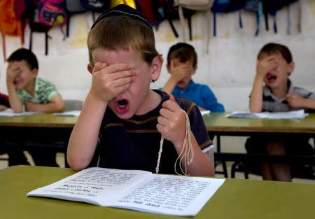 Ultra Orthodox students gesture as they pray during a reading class at the Kehilot Yaacov Torah School for boys in Ramot neighbourhood in Jerusalem June 24, 2010. REUTERS/ Ronen Zvulun/File Photo