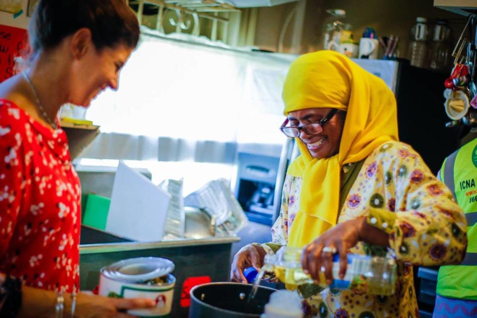 Patricia Salahuddin, a la derecha, se ríe mientras cocina comida caliente para la población local tras el huracán Irma en Masjid Al-Ansar.