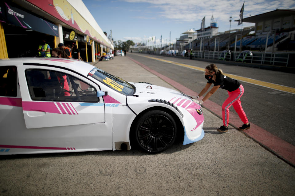 Vitarti Girl's Team mechanic Victoria Pascual pushes one of her team's racing cars into pits after a practice session at the Oscar y Juan Galvez track in Buenos Aires, Argentina, Friday, April 2, 2021. The Vitarti Girl's Team is the first all-female team in Argentina's motorsport history. (AP Photo/Natacha Pisarenko)