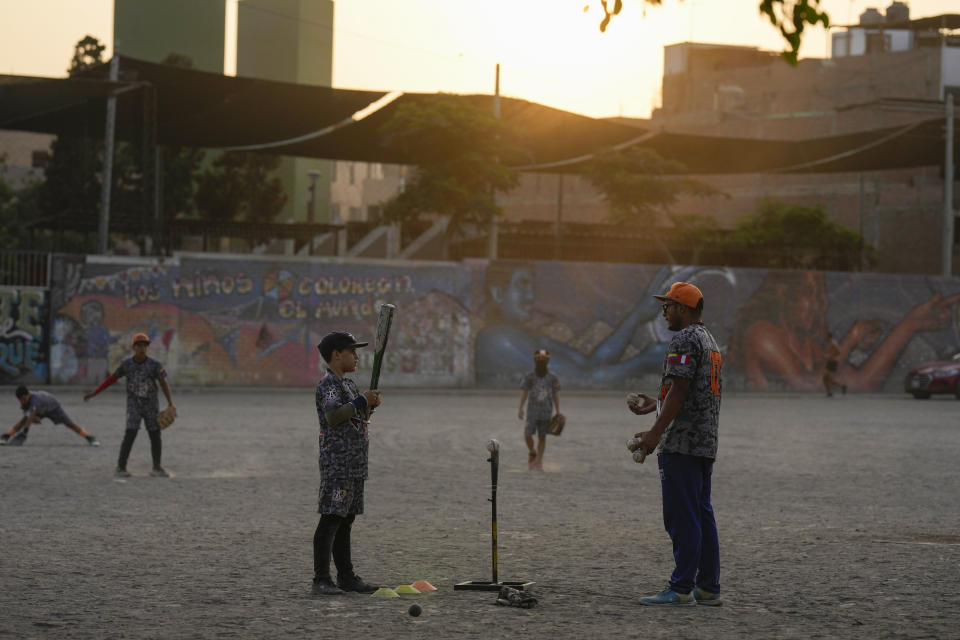 Venezuelan migrant Deremi Becerra talks to coach Franklin Lopez during a baseball practice in a public park in the Comas area, on the outskirts of Lima, Peru, Thursday, May 9, 2024. Immigrants, mainly Venezuelans, have opened five baseball academies in Peru's capital. (AP Photo/Martin Mejia)