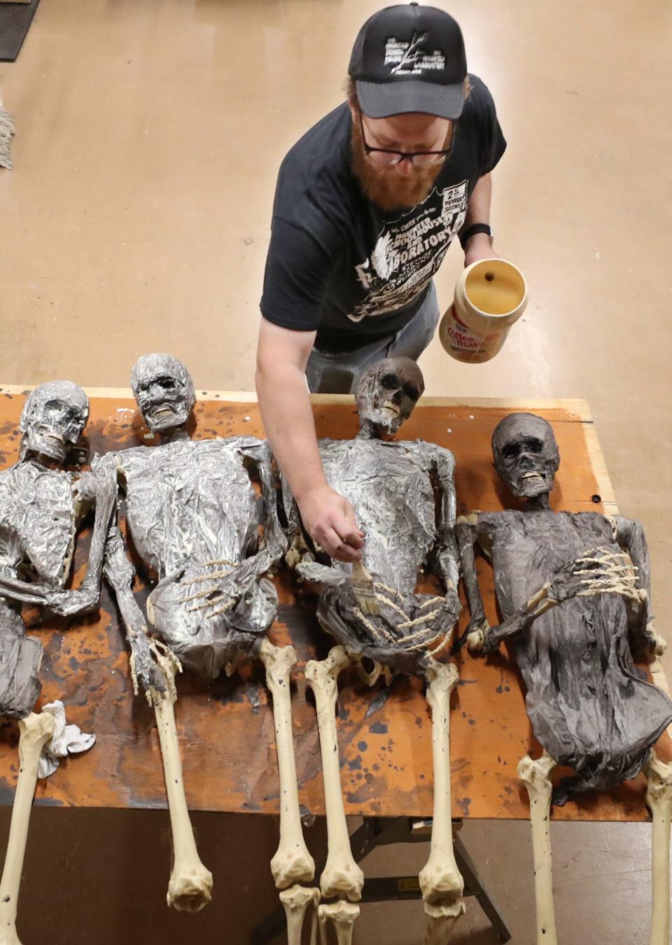 Dave Shonk, production manager at the Haunted Schoolhouse prepares mummies for a new display.