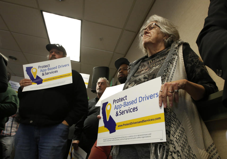 FILE - In this Oct. 29, 2019, file photo, Carla Shrive, right, who drives for various gig companies, joined other drivers to support a proposed ballot initiative challenging a recently signed law that makes it harder for companies to label workers as independent contractors, in Sacramento, Calif. A battle between the powerhouses of the so-called gig economy and big labor could become the most expensive ballot measure on Nov. 3, 2020, in California history. Voters are being asked to decide via Proposition 22 whether to create an exemption to a new state law aimed at providing wage and benefit protections to Uber, Lyft and other app-based drivers. (AP Photo/Rich Pedroncelli, File)