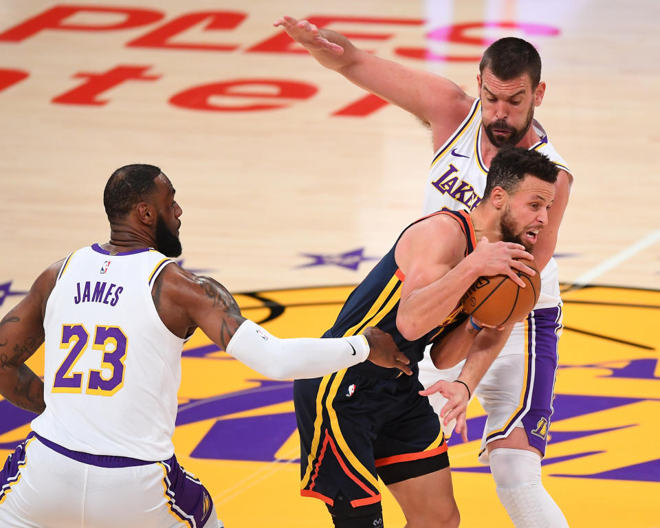 Feb 28, 2021; Los Angeles, California, USA;  Golden State Warriors guard Stephen Curry (30) is defended by Los Angeles Lakers forward LeBron James (23) and center Marc Gasol (14) as he takes the ball down court in the first quarter of the game at Staples Center. Mandatory Credit: Jayne Kamin-Oncea-USA TODAY Sports