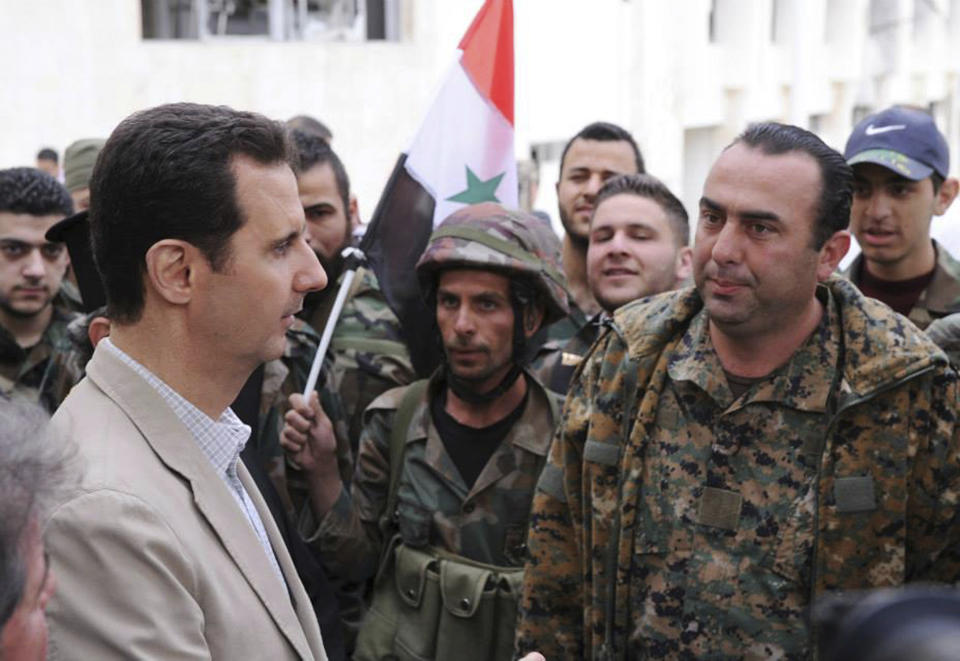 FILE - In this April 20, 2014 file photo, released by the Syrian official news agency SANA, Syrian President Bashar Assad, left, talks to government soldiers during his visit to the Christian village of Maaloula, near Damascus, Syria. U.S. Secretary of State Rex Tillerson’s statement Tuesday, April 11, 2017, that the reign of President Bashar Assad’s family “is coming to an end” suggests Washington is taking a much more aggressive approach about the Syrian leader. Taking him out of the equation without a clear transition plan would be a major gamble. (SANA via AP, File)