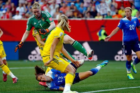 Jun 12, 2015; Winnipeg, Manitoba, CAN; United States forward Alex Morgan (13) falls after colliding with Sweden goalkeeper Hedvig Lindahl (1) during the second half in a Group D soccer match in the 2015 FIFA women's World Cup at Winnipeg Stadium. The game ended in a draw 0-0. Mandatory Credit: Michael Chow-USA TODAY Sports