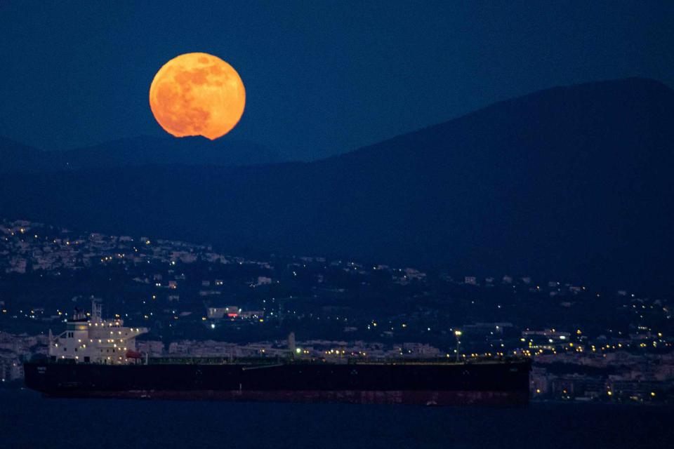<p>NurPhoto/Getty Images</p> Super Flower Moon of May 2020 as seen rising over the Aegean Sea and Thessaloniki city in Greece from Kalochori