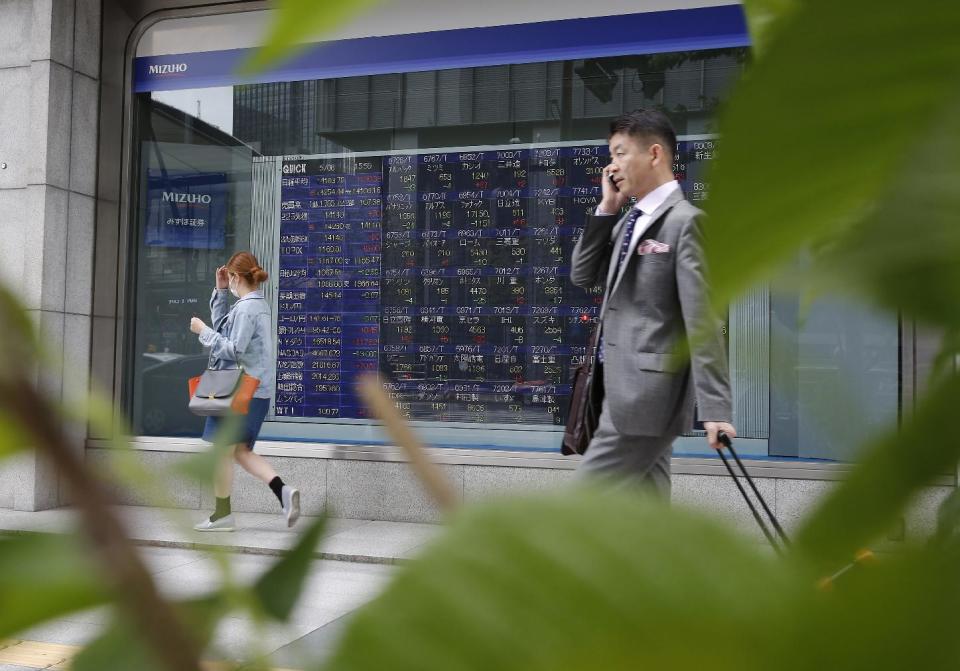 People walk past an electronic stock indicator in Tokyo Thursday, May 8, 2014. Asian stock markets were mostly higher Thursday after China's trade improved and Federal Reserve Chair Janet Yellen vowed low interest rates would continue until the U.S. job market is healthy. Tokyo's Nikkei 225 stock index, the region's heavyweight, advanced 0.9 percent to 14,163.78. (AP Photo/Shizuo Kambayashi)