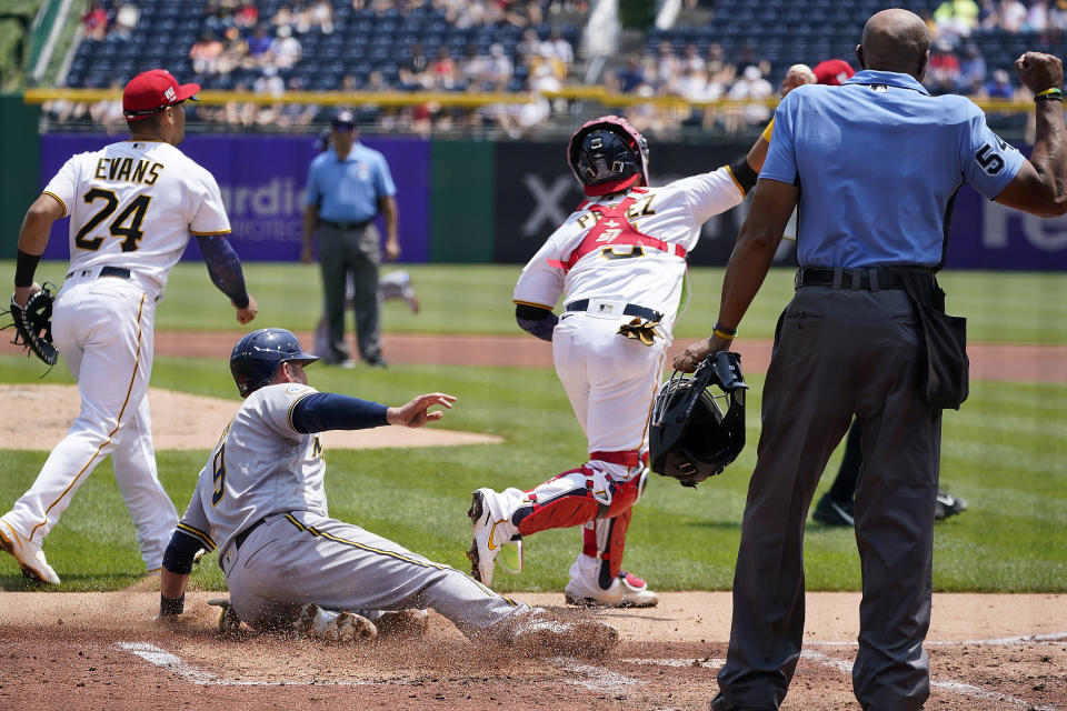 Umpire C.B. Bucknor, right, calls Milwaukee Brewers' Manny Pina (9) out when Pina was attempting to score on a bunt by Freddy Peralta as Pittsburgh Pirates catcher Michael Perez, second from right, throws to first to complete a double play on Peralta and end the top of the second inning of a baseball game in Pittsburgh, Sunday, July 4, 2021. (AP Photo/Gene J. Puskar)