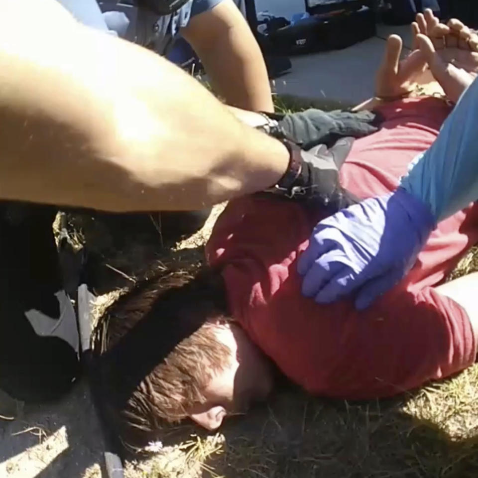 In this image from Colorado Springs Police Department body-camera video, police restrain Hunter Barr outside his father’s home in Colorado Springs, Colo., on Sept. 25, 2020. Retired postal worker Mark Barr had called 911 for help controlling his son, who he said wasn't violent but was having a bad reaction to LSD. He watched as a medic gave two injections. His son was dead within hours. "I couldn't figure out why that was necessary," he said of the second injection. (Colorado Springs Police Department via AP)