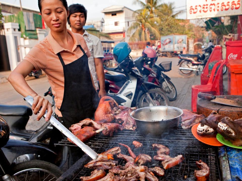 A person grills dog meat in Cambodia in 2013.