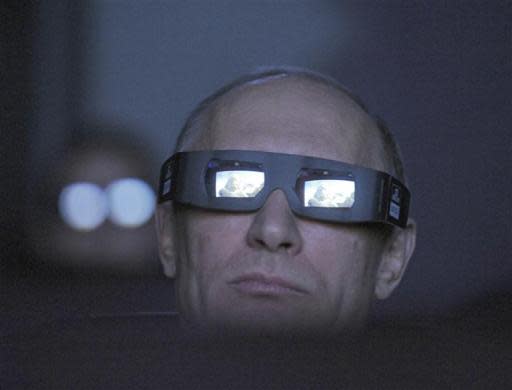 Russia's Prime Minister and President-elect Vladimir Putin, wearing a pair of glasses, watches the main program of the Planetarium on the Day of Aviation and Cosmonautics and the 51st anniversary of Yuri Gagarin's historic first space flight in Moscow April 12, 2012.