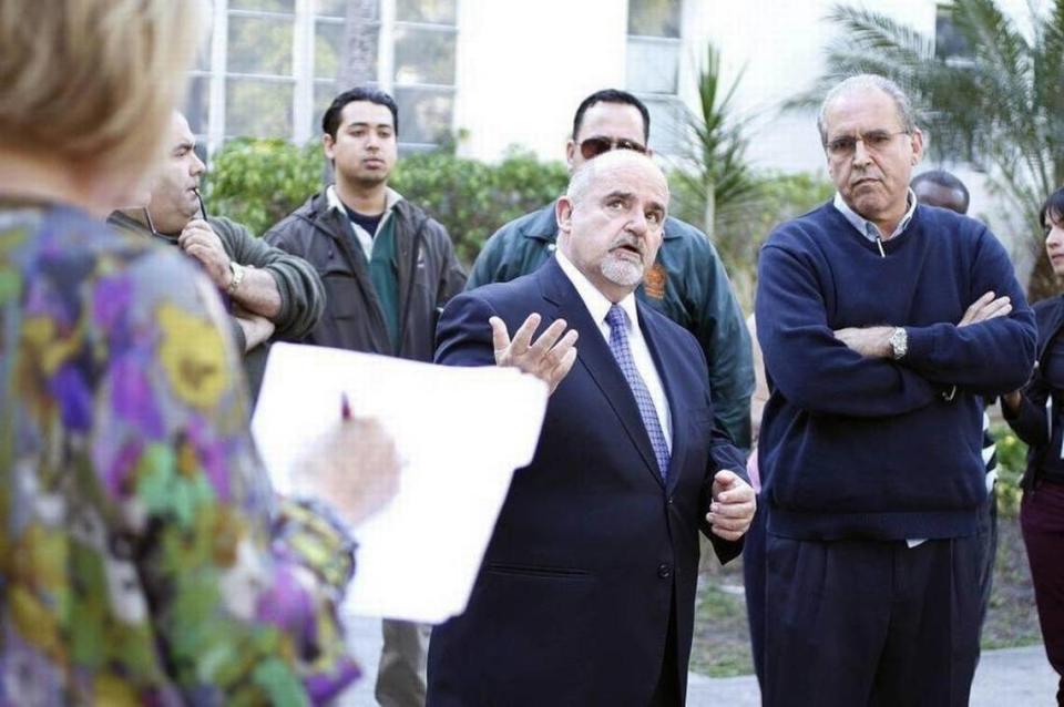 Mariano Fernandez, center, surrendered to the Miami-Dade state attorney’s office Tuesday on a charge of receiving unlawful compensation while serving as Miami Beach’s building official.