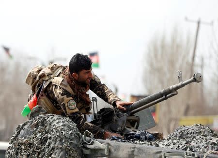 A member of the Afghan security forces prepares his machine gun at the site of a suicide bomb attack near a Shi'ite mosque in Kabul, Afghanistan March 9, 2018. REUTERS/Omar Sobhani