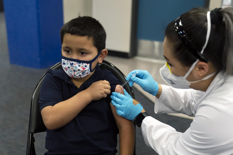 FILE - Six-year-old Eric Aviles receives the Pfizer COVID-19 vaccine from pharmacist Sylvia Uong at a pediatric vaccine clinic for children ages 5 to 11 set up at Willard Intermediate School in Santa Ana, Calif., Tuesday, Nov. 9, 2021. In a statement Sunday, Nov. 28, 2021, California's public health officer, Dr. Tomas J. Aragon, said that officials are monitoring the Omicron variant. There are no reports to date of the variant in California, the statement said. Aragon said the state was focusing on ensuring its residents have access to vaccines and booster shots. (AP Photo/Jae C. Hong, File)