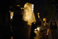 A demonstrator raises a fist near Philadelphia police in Philadelphia, late Tuesday, Oct. 27, 2020. Hundreds of demonstrators marched in West Philadelphia over the death of Walter Wallace Jr., a Black man who was killed by police in Philadelphia on Monday. Police shot and killed the 27-year-old on a Philadelphia street after yelling at him to drop his knife. (AP Photo/Matt Slocum)