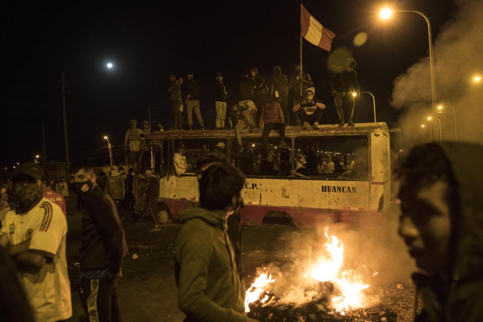 Farmworkers use a bus as a barricade to block the Pan-American highway during a protest in Villacuri, Ica province, Peru, Wednesday, Dec. 2, 2020. The workers are demanding better wages and health benefits. (AP Photo/Rodrigo Abd)