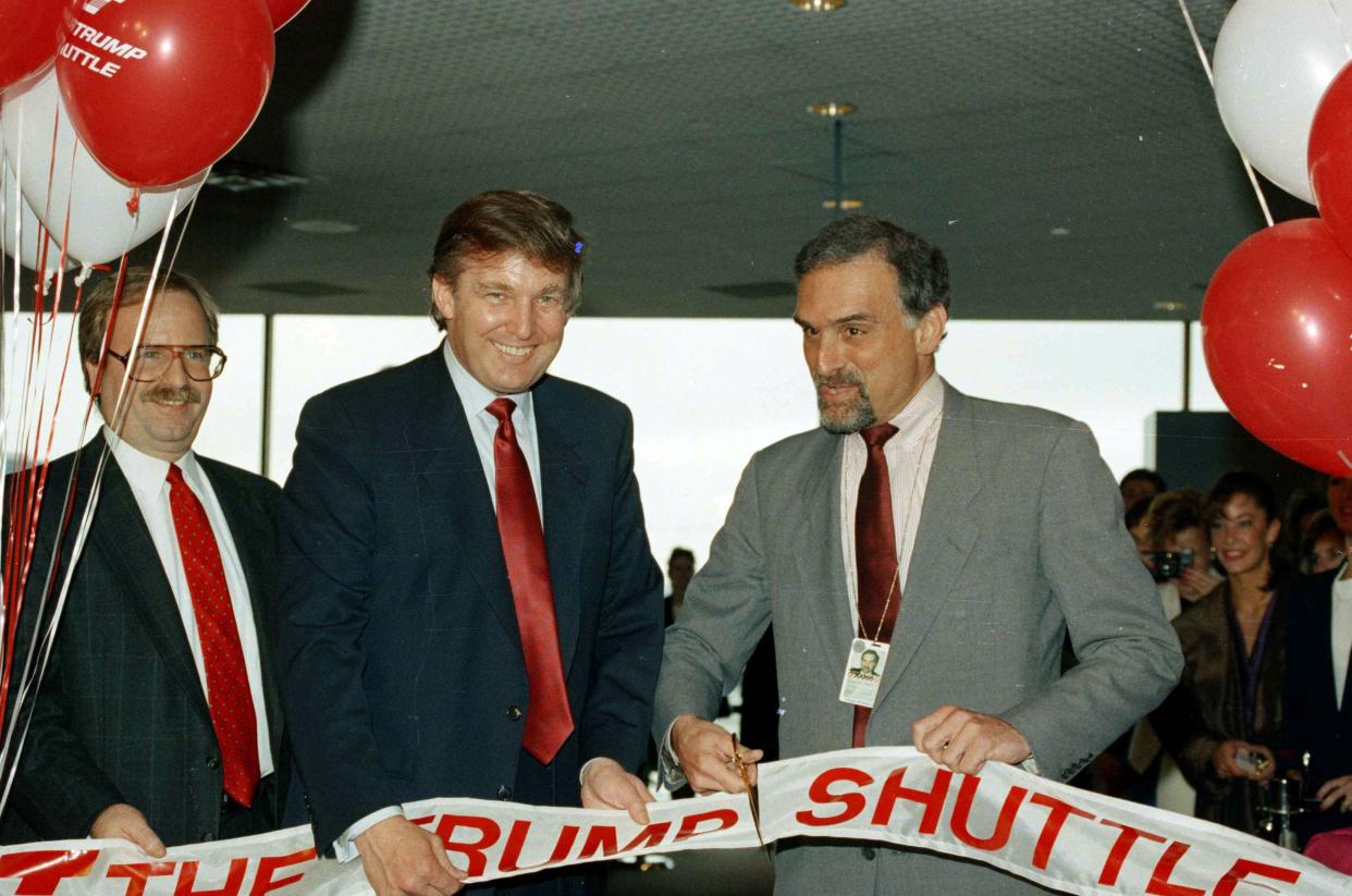 Donald Trump, left, holds the ribbon on June 8, 1989 at Logan International Airport in Boston, as Massport deputy-executive director Patrick Moscaritolo cuts it to officially open the Trump airline terminal at Logan Airport.