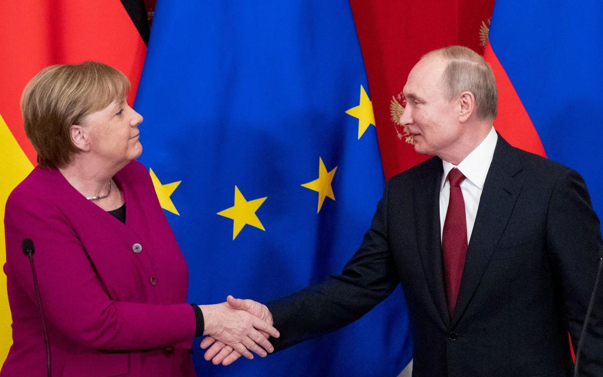 (FILES) This file photo taken on January 11, 2020 shows Russia's President Vladimir Putin (R) and then Germany's Chancellor Angela Merkel shaking hands at the end of their joint press conference after their meeting at the Kremlin in Moscow. - German former chancellor Angela Merkel, whose conciliatory policies toward the Kremlin while in office have come under fire, on February 25, 2022 condemned Russia's invasion of Ukraine. Merkel's decision to maintain close diplomatic and economic ties with Russia despite years of provocations have been criticised as "naive" in recent days as Putin has laid bare his intentions in Ukraine. (Photo by Pavel Golovkin / POOL / AFP) (Photo by PAVEL GOLOVKIN/POOL/AFP via Getty Images) - PAVEL GOLOVKIN/POOL/AFP via Getty Images