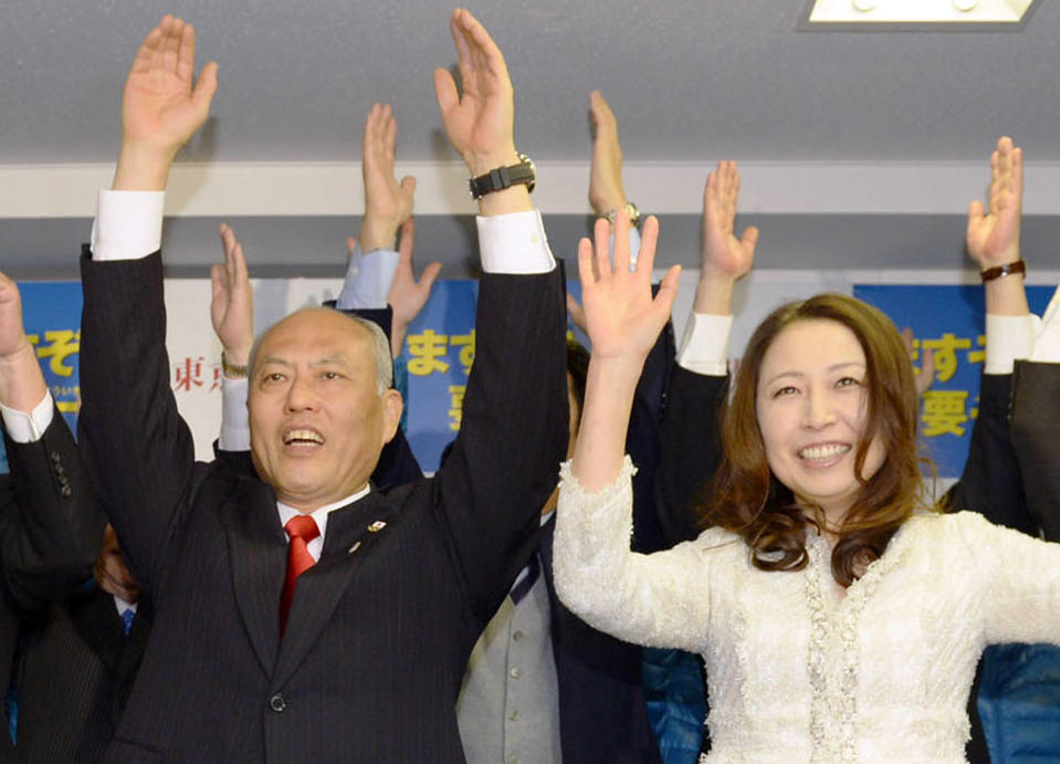 Former Health Minister Yoichi Masuzoe, left, and his wife Masami celebrate his gubernatorial election victory at his election office in Tokyo, Sunday, Feb. 9, 2014. Masuzoe, backed by Japan's ruling party, won Tokyo's gubernatorial election on Sunday, defeating two candidates who had promised to end nuclear power. (AP Photo/Kyodo News) JAPAN OUT, MANDATORY CREDIT