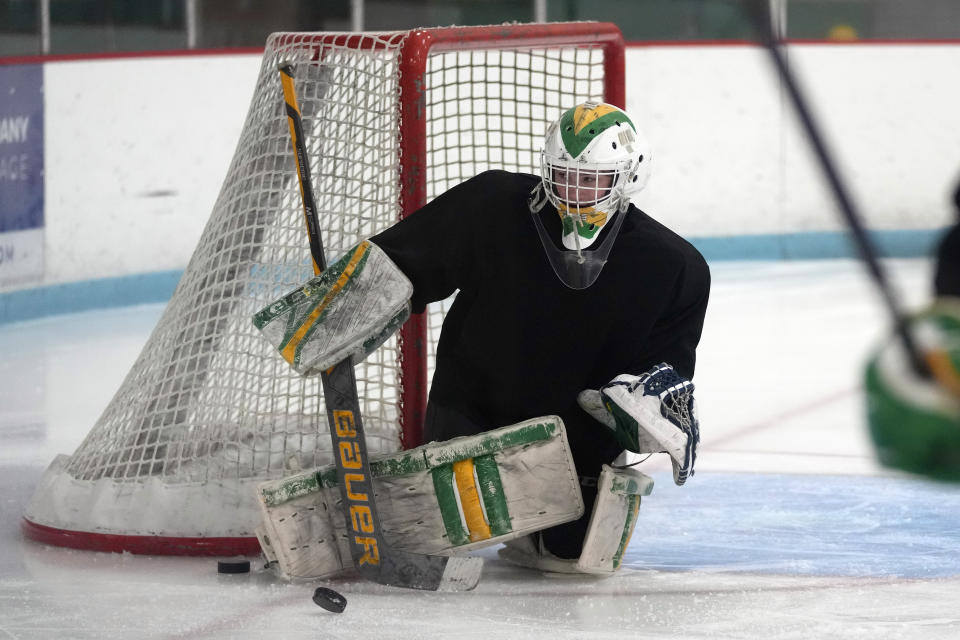 Evan Smolik stops a shot during hockey practice Wednesday, Nov. 29, 2023, in Edina, Minn. When Evan was 14, a teammate's skate struck his neck and his jugular vein, but the neck guard he was wearing prevented the skate from cutting his carotid artery and helped save his life. (AP Photo/Abbie Parr)