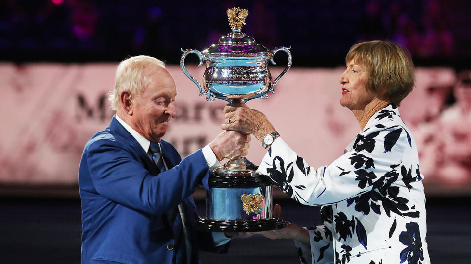 Seen here, Rod Laver hands Margaret Court a replica Australian Open trophy.