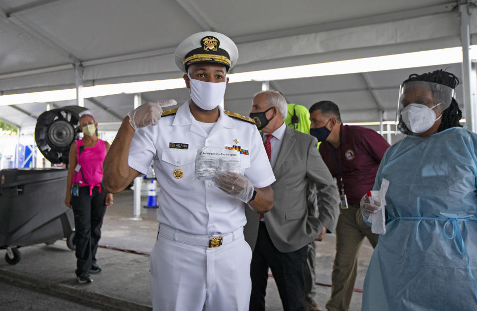 Vice Admiral Jerome Adams, the U.S. Surgeon General, speaks with the media alongside health care worker Varaiaia Barkus at the COVID-19 drive-thru testing center at Miami-Dade County Auditorium in Miami on Thursday, July 23, 2020. (David Santiago/Miami Herald/Tribune News Service via Getty Images)