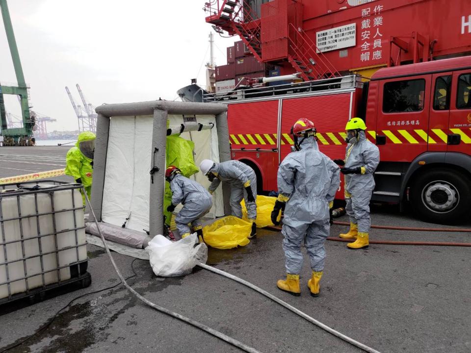 高雄港傳貨櫃氫氟酸外洩，港務消防人員出動救災。（翻攝畫面）