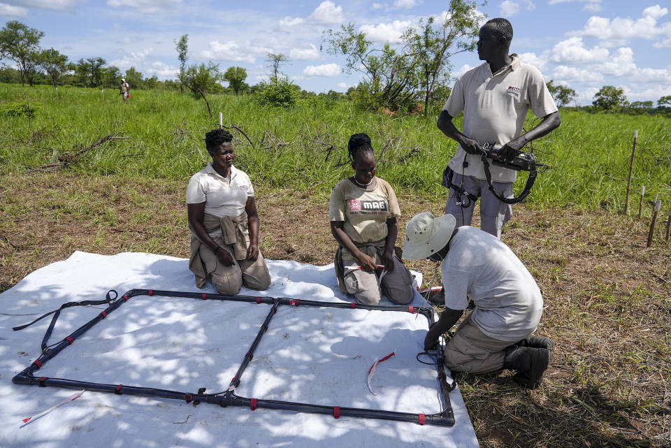 Deminers from the Mines Advisory Group (MAG) prepare to do clearance at a site containing cluster munitions in Ayii, Eastern Equatoria state, in South Sudan Thursday, May 11, 2023. As South Sudanese trickle back into the country after a peace deal was signed in 2018 to end a five-year civil war, many are returning to areas riddled with mines left from decades of conflict. (AP Photo/Sam Mednick)