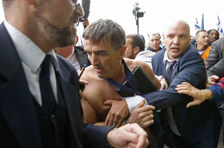 File photo of a shirtless Xavier Broseta (C), Executive Vice President for Human Resources and Labour Relations at Air France, who was evacuated by security after employees interrupted a meeting with representatives staff at the Air France headquarters building at the Charles de Gaulle International Airport in Roissy, near Paris, France, in this picture taken October 5, 2015. REUTERS/Jacky Naegelen/File Photo