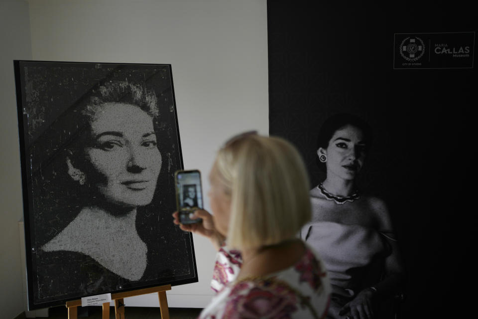A woman takes photos, of a painting depicting Greek Soprano Maria Callas, at the newly established Museum, the first dedicated to the legendary opera star, in Athens, Greece, Wednesday, Oct. 25, 2023. The new museum presents, priceless historical artifacts, including photographs and portraits, rare live recordings, and a unique collection of records and personal items as this year is the 100th anniversary of Maria Callas' birth. (AP Photo/Thanassis Stavrakis)