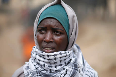 Female demonstrator Aya is affected by tear gas fired by Israeli troops during a protest where Palestinians demand the right to return to their homeland, at the Israel-Gaza border, east of Gaza City April 20, 2018. REUTERS/Mohammed Salem