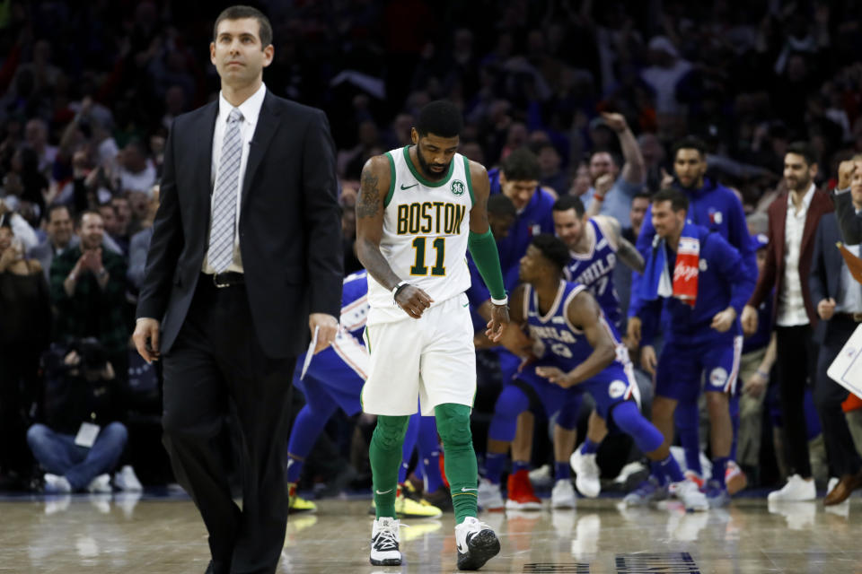 Boston Celtics' Kyrie Irving, center, and coach Brad Stevens, left, walk the court for a timeout after Jimmy Butler scored a basket during the second half of an NBA basketball game Wednesday, March 20, 2019, in Philadelphia. Philadelphia won 118-115. (AP Photo/Matt Slocum)