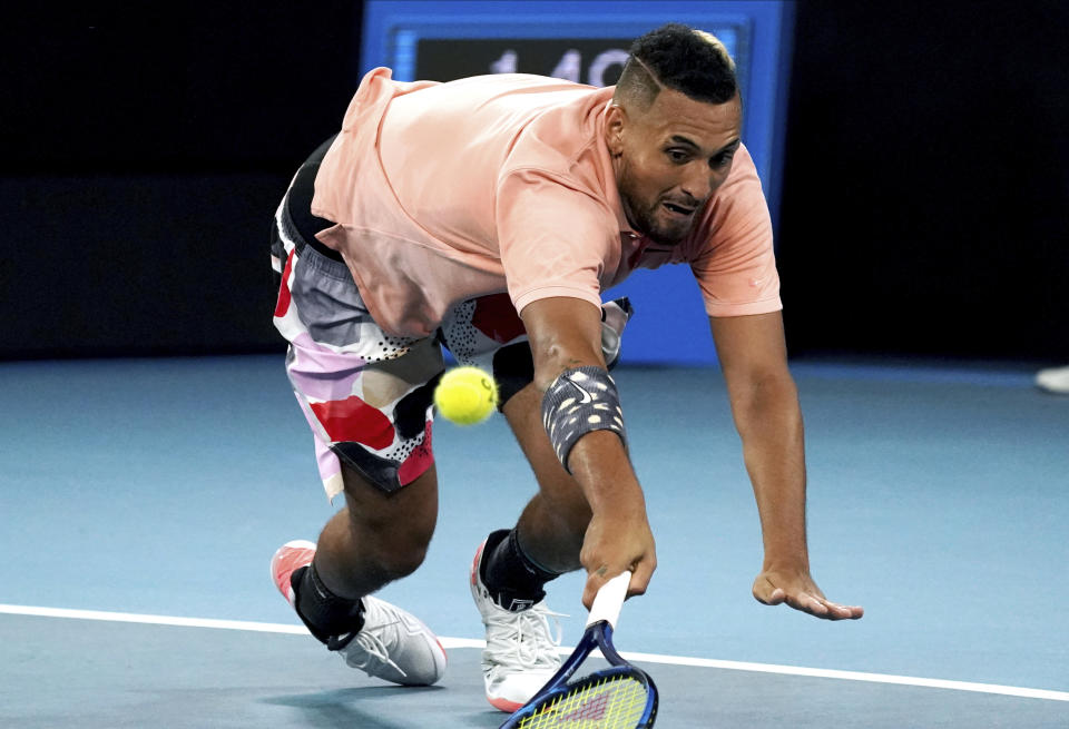 Australia's Nick Kyrgios dives to make a backhand return to Russia's Karen Khachanov during their third round singles match at the Australian Open tennis championship in Melbourne, Australia, Saturday, Jan. 25, 2020. (AP Photo/Lee Jin-man)