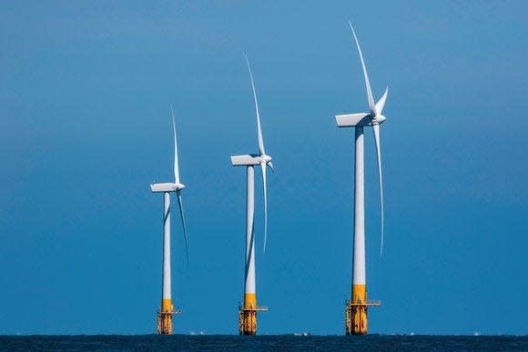 Three offshore wind turbines in the distance.