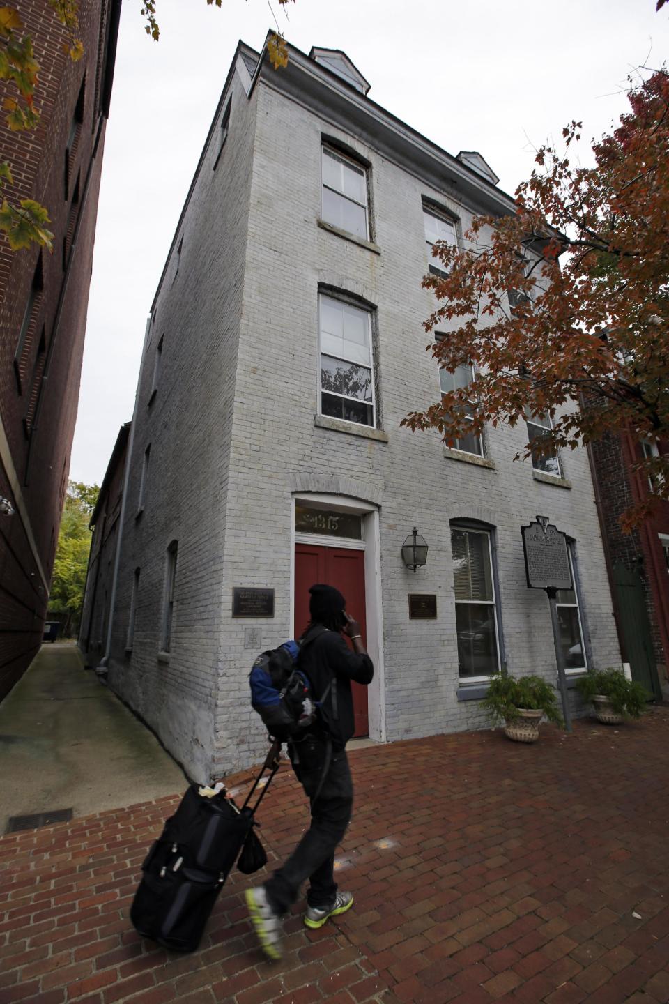 This photo taken Oct. 31, 2013 shows a person walking past the Freedom House Museum in Alexandria, Va. A small museum across the Potomac River from the nation's capital is connected to the story depicted in the new movie “12 Years a Slave.” The Freedom House Museum is at the site where a major slave trader once operated _ the same slave trader who sold Solomon Northrup into slavery after the free man's abduction. The movie is drawing renewed interest from historians and visitors in this Virginia city’s role in the slave trade. (AP Photo/Alex Brandon)