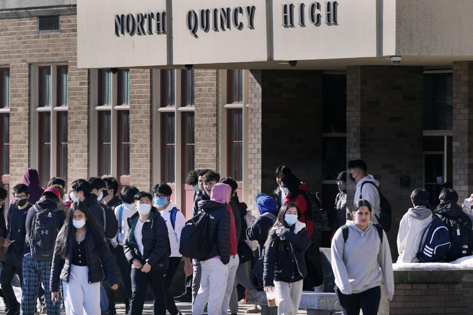 FILE - Students, most wearing protective face masks over concerns for coronavirus, walk from North Quincy High School at the end of the school day in Quincy, Mass., Monday, Feb. 28, 2022. U.S. COVID-19 cases are up, leading a smattering of school districts, particularly in the Northeast, to bring back mask mandates and recommendations for the first time since the omicron winter surge ended and as the country approaches 1 million deaths in the pandemic. (AP Photo/Charles Krupa, File)