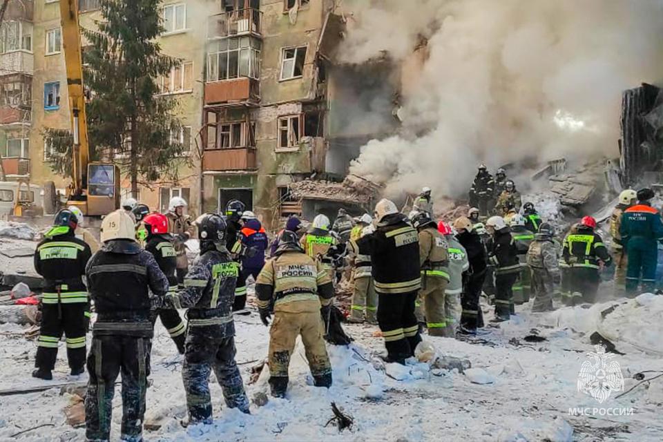 In this photo released by the Russian Emergency Ministry Press Service, Emergency service employees work at a site of a five-story residential building collapsed after a gas explosion in the Siberian city of Novosibirsk, Russia, Thursday, Feb. 9, 2023. Authorities say a gas explosion in an apartment building in the Siberian city of Novosibirsk has killed at least five people including a 2-year-old child. The explosion at 7:43 a.m. on Thursday caused two entrances of the five-story building to collapse, with 30 apartments destroyed by the ensuing fire. (Russian Emergency Ministry Press Service via AP)