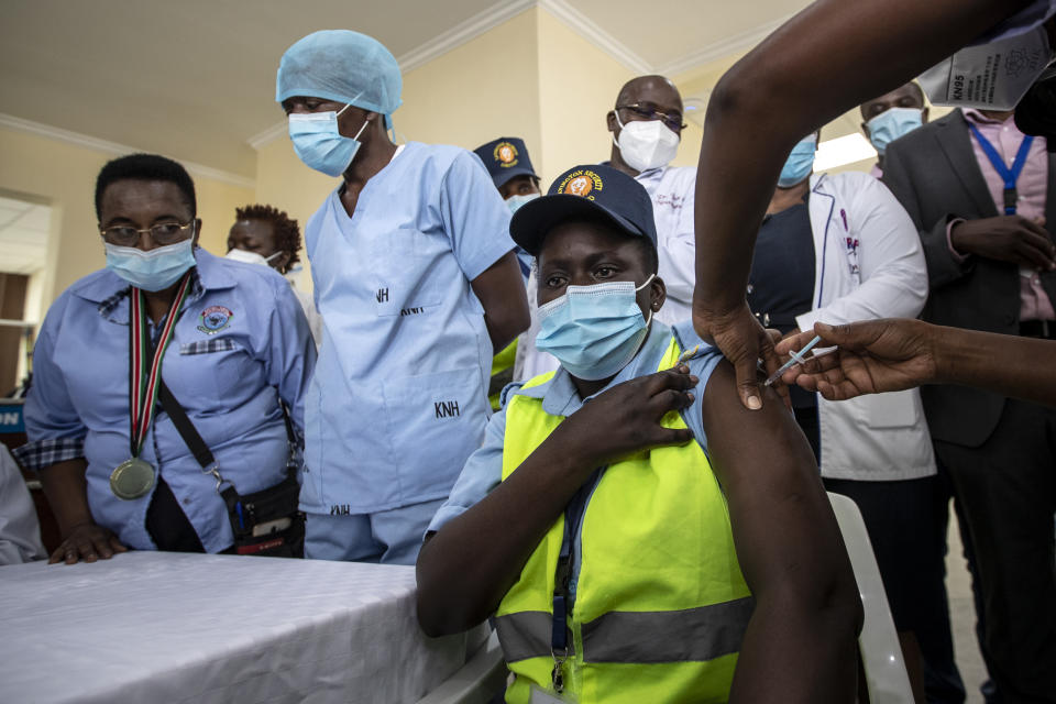 FILE - In this March 5, 2021, file photo, a hospital security guard receives one of Kenya's first AstraZeneca COVID-19 vaccinations provided through the global COVAX initiative, at Kenyatta National Hospital in Nairobi. While COVAX is providing vaccines to poorer countries lacking the clout to negotiate for them on their own, it has only cleared 2 million doses in the past two weeks because nearly all deliveries through the global program are blocked until as late as June. (AP Photo/Ben Curtis, File)